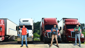three men in front of their trucks